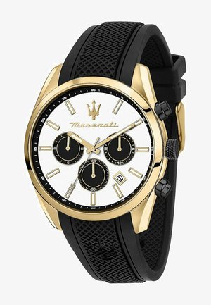 Gouden horloge met een witte wijzerplaat, drie zwarte subdials en een datvenster. Voorzien van een zwarte rubberen band met een gepatineerde textuur en drukknoppen.