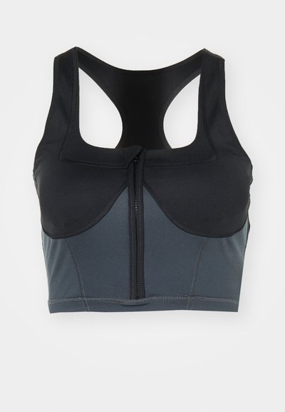 Reggiseno sportivo in nero e grigio scuro, con zip frontale, spalline larghe e dettagli delle cuciture per una maggiore struttura e supporto.