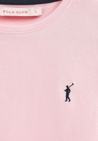 Rosa Baumwoll-T-Shirt mit einem dunkelblauen bestickten Logo einer Person, die mit einem Hammer geht. Rundhals, weicher Stoff und kurze Ärmel.