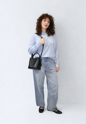 Cămașă albastru deschis cu mâneci lungi și nasturi, asortată cu blugi decolorați cu talie înaltă și o geantă mică de mână din piele neagră.