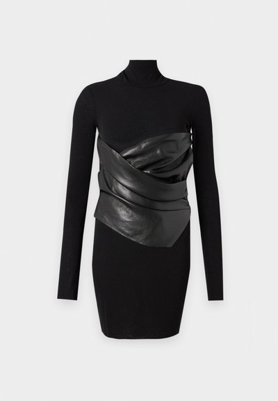 Robe noire à manches longues avec un panneau en cuir noir texturé et drapé au niveau de la taille. Tissu lisse et silhouette ajustée.