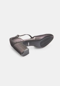 Black high-heeled shoe with a textured fabric upper, a round toe, and a thick block heel. Features an ankle strap and a rubber sole.