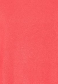 Tissu en maille corail présentant une texture lisse avec un fin côtelé. Couleur uniforme sans motifs ni accents visibles.