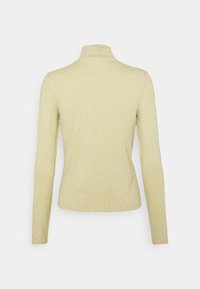 Langärmliges Turtleneck-Oberteil aus weichem, dehnbarem Stoff in Hellgelb mit weißen Pünktchen. Glatte Textur und taillierte Passform.