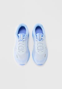 Un par de zapatillas de running Nike en tonos azul claro y blanco, con tejido de malla y cordones, vistas desde arriba sobre un fondo blanco.