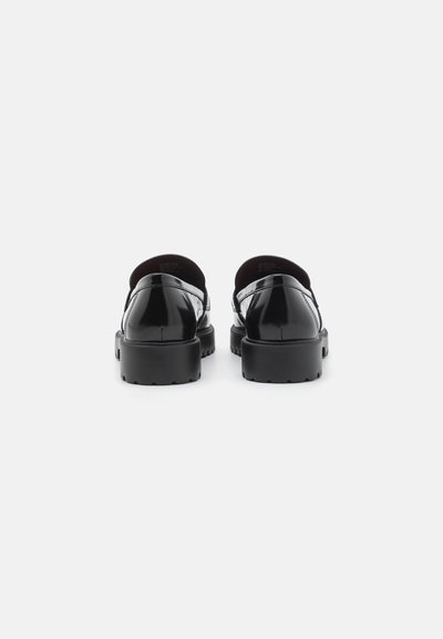 Zapatos de charol negro con tacones redondeados, suelas gruesas y un diseño minimalista. Textura lisa sin herrajes o patrones visibles.