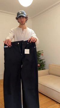 Μαύρο τζιν παντελόνι με ίσια γραμμή, πέντε τσέπες, ασημένια μεταλλικά στοιχεία, φερμουάρ και ετικέτα με την ένδειξη "Calvin Klein Jeans".