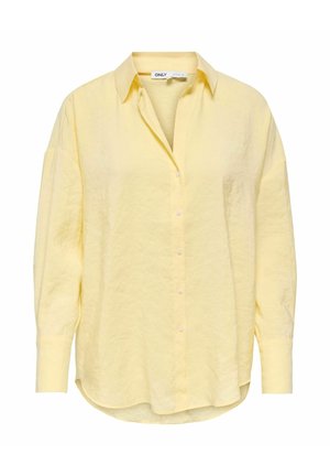 Blouse à manches longues de couleur jaune clair avec un col, une patte de boutonnage sur le devant et un ourlet légèrement incurvé, confectionnée dans un tissu doux et texturé.