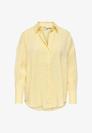 Blouse à manches longues de couleur jaune clair avec un col, une patte de boutonnage sur le devant et un ourlet légèrement incurvé, confectionnée dans un tissu doux et texturé.