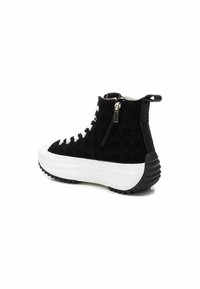 Botín negro texturizado hasta el tobillo con una suela blanca gruesa, que cuenta con cordones en la parte frontal, cierre lateral y detalle de goma negra en el tacón.