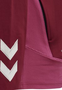 Burgunderroter und pinker strukturierter Sportstoff mit zwei weißen Chevron-Streifen auf der linken Seite.