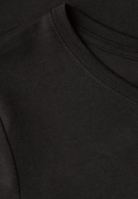 Schwarzer Baumwoll-T-Shirt-Stoff, weiche Textur, Rundhalsausschnitt mit Rippbündchen, flache Nähte, überlappende Lagen, minimalistische Details.