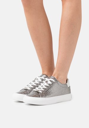 Šedé tenisky s bílé tkaničky a bílou podrážkou. Texturovaný svršek má jemný kruhový vzor. Zaoblená špička a kontrastní pata.