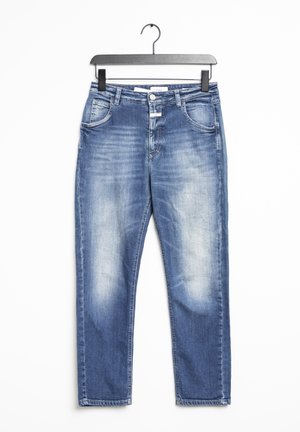 Jean en denim bleu délavé avec poches avant et passants de ceinture, suspendu sur un cintre noir sur fond blanc.