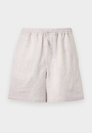 Mand iført en hvid tekstureret kortærmet skjorte, beige shorts, sorte sandaler og bærende en stor brun læder skuldertaske.