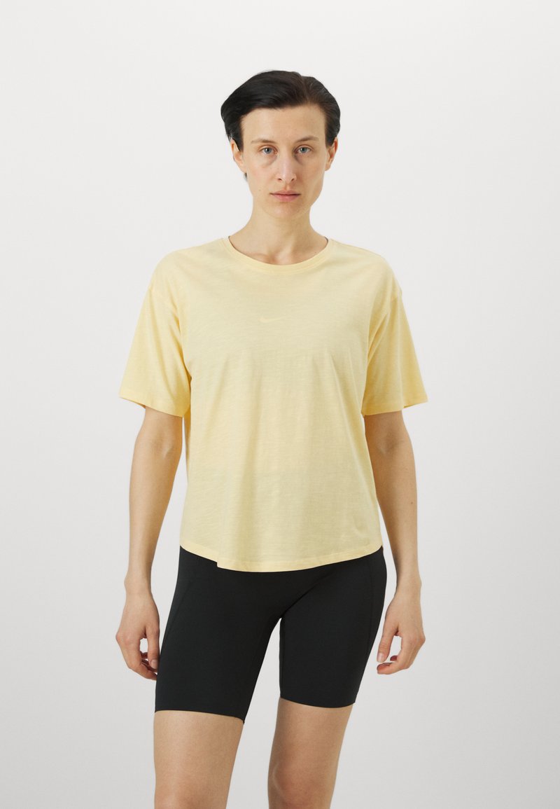 Gul kortermet t-skjorte med avslappet passform. Mykt, lett stoff med en subtil tekstur. Pair med svarte, tettsittende shorts.