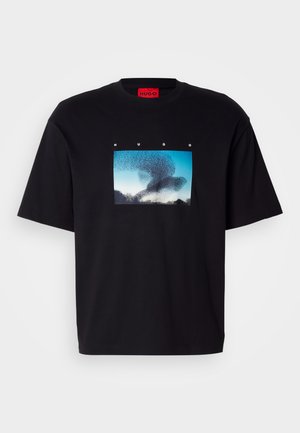 Black cotton t-shirt featuring a rectangular graphic with a blue sky and abstract shapes. Crew neckline and short sleeves.