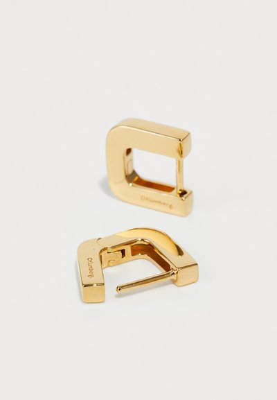 Goldene Metall-Hoops mit einem kantigen Design, das mit einer glänzenden Oberfläche und einer klaren, modernen Ästhetik aufwartet. Bemerkenswert ist das U-förmige Öffnungsdetail.