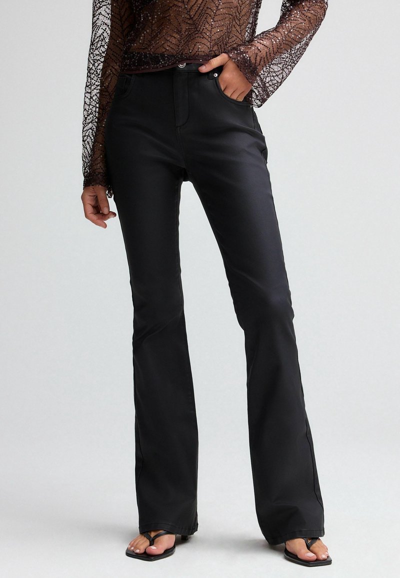 Black flared trousers with a smooth texture, featuring a classic button closure, five pockets, and a streamlined silhouette.
