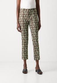 Brune og grønne bukser med bladmønster, slim fit og cropped længde, lavet af let stof, parret med sorte hæle slides.