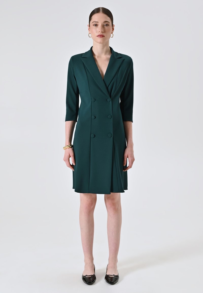 Türaublaues, doppelt geknöpftes Kleid mit taillierter Passform, Dreiviertelärmeln und plissiertem Rock. Glattes Material mit einem glänzenden Finish.