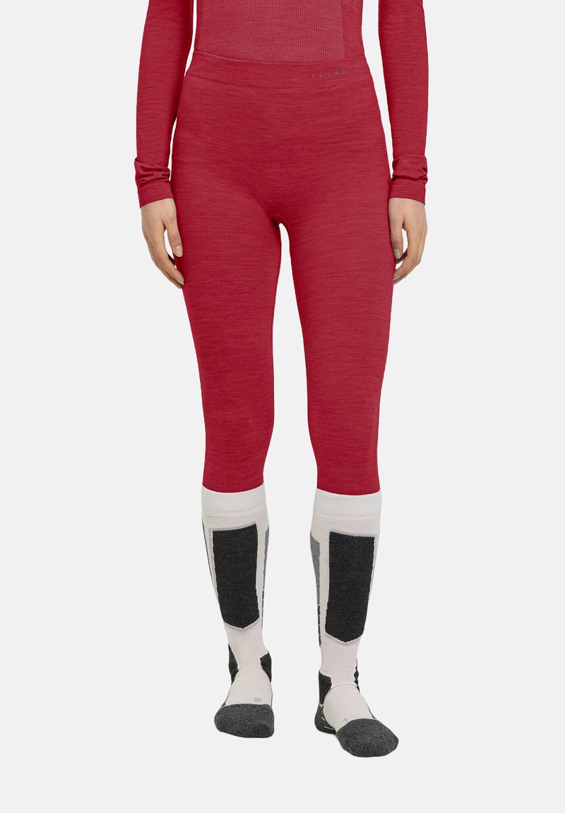 Enganliegende rote Leggings aus einem strukturierten Material, kombiniert mit mehrfarbigen knielangen Socken mit grauen Akzenten und einem gemusterten Design.