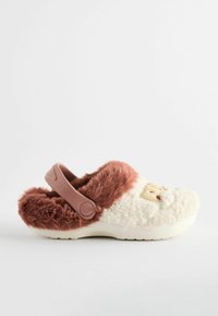Sabot moelleux blanc et marron avec une texture douce, doté d'une sangle arrière rose et d'un détail de broderie faciale à l'avant.