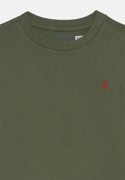 Camiseta de color verde oliva con cuello redondo, hecha de una tela suave, que presenta un pequeño logo bordado en rojo en el lado izquierdo del pecho.