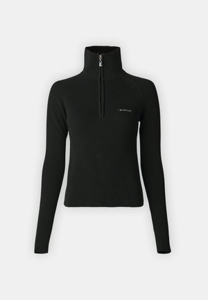 Top negru cu nervuri, cu fermoar, guler înalt, mâneci lungi și un design ajustat. Prezintă un mic logo pe piept. Potrivit pentru stratificare.