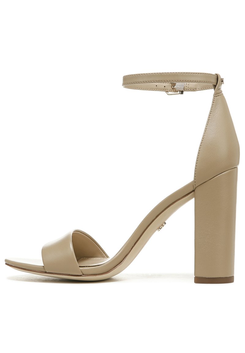 Beige hoge hakken sandalen met een gladde leren afwerking, een enkelbandje, open teen ontwerp en een blokhak voor stabiliteit.