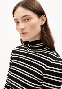 Schwarz-weiße gestreifte Rollkragenoberteil mit gerippter Textur, das horizontale Streifen und einen enganliegenden Kragen aufweist.