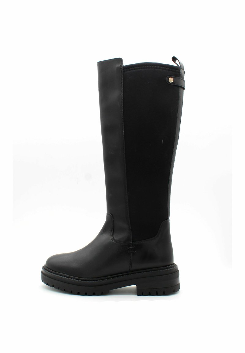 Botas negras hasta la rodilla fabricadas en cuero suave, con una suela plana, costuras reforzadas y una correa de acento en la parte superior.