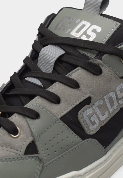 Μαύρο και γκρι αθλητικό παπούτσι με μαύρα κορδόνια, λογότυπο 'GCOS' στη γλώσσα και στο πλάι, με πάνελ από σουέντ και δέρμα.