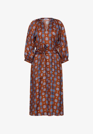Vestito midi color ruggine con motivi floreali e geometrici blu e bianchi, maniche lunghe a sbuffo, scollo a V e cintura annodata in vita.