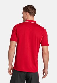 Rode polo shirt gemaakt van een gladde stof, met een contrasterende witte kraag en korte mouwen. Eenvoudig ontwerp met schone lijnen.