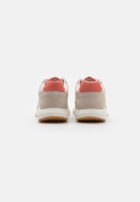 Sneaker beige con tomaia in morbido suede e pelle, dettagli corallo e suola in gomma texturizzata, viste da dietro.