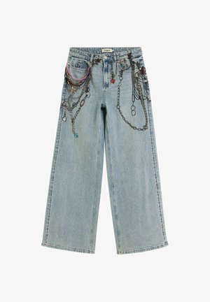Blugi din denim albastru deschis cu croială largă, decorați cu detalii complicate de lanțuri și talismane, având o croială lejeră și accente în culori contrastante.