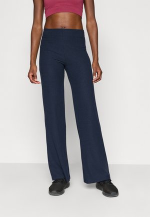 Pantalons larges à côtes navy avec une taille haute, fabriqués en tissu extensible, présentant une texture lisse et une coupe décontractée.