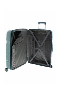 Koffer met harde schaal in teal, met een ritsvak en elastische kruistraps aan de binnenkant. Voorzien van een uitschuifbaar handvat en vier wielen.