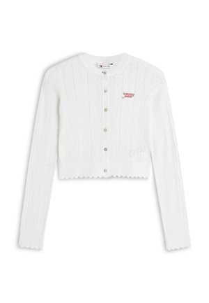 Cardigan court blanc à manches longues, boutonnière devant, bords festonnés, motif tricoté et logo rouge "tommy jeans" sur la poitrine gauche.