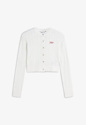 Cardigan bianco corto con maniche lunghe, chiusura con bottoni sul davanti, bordi smerlati, motivo a maglia e logo rosso "tommy jeans" sul petto sinistro.
