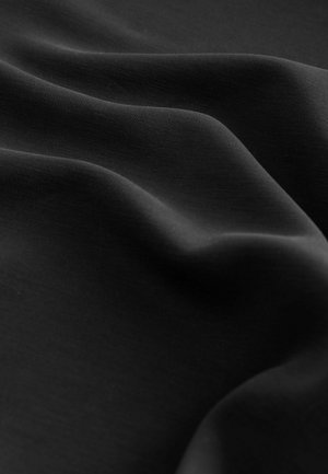 Tessuto nero con una texture liscia, che mostra morbide pieghe e una leggera lucentezza. Il materiale appare leggero e flessibile.