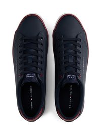 Mørkeblå lædersneakers med hvide såler, kontrasterende røde detaljer, snørebåndsdesign og logo-detaljer på siden og tungen.