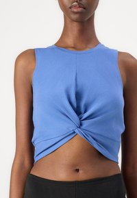 Sinine lühike torso, valmistatud sileda kangaga, mis sisaldab vöökoha juures keeratud sõlme ja ümmargust dekolteed.