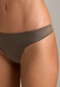 Rjave bombažne bikini hlačke z brezšivno zasnovo, tankim pasom in minimalnim pokrivanjem, z gladko in mehko teksturo.