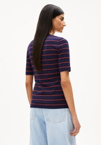 Navyblaues T-Shirt mit roten horizontalen Streifen. Hat einen runden Halsausschnitt und eine taillierte Silhouette. Aus weichem, dehnbarem Stoff.