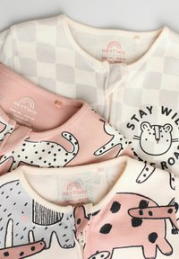Trois bodys en tissu doux pour bébés : un avec un motif à carreaux, un avec des imprimés d'animaux et un avec du texte. Les couleurs incluent le rose clair et le crème.