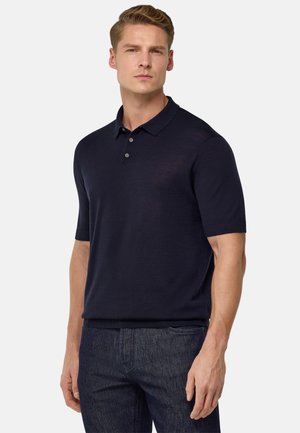 Camisa polo marina hecha de una mezcla de algodón, con un collar clásico, mangas cortas y una tapeta de tres botones. Tejido texturizado.