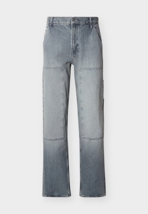 Grå denimbukser med høyt liv, store rektangulære knelapper og vid benkutt, med lommer foran og knappelukking.