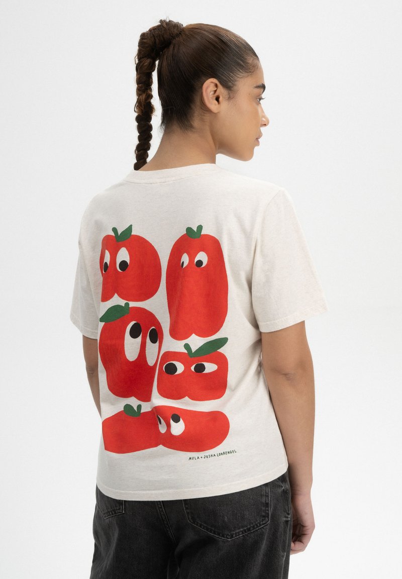 Cremefarbenes Baumwoll-T-Shirt mit einem bunten Druck von roten Paprika mit Augen auf dem Rücken. Kurze Ärmel, lässige Passform und runder Halsausschnitt.
